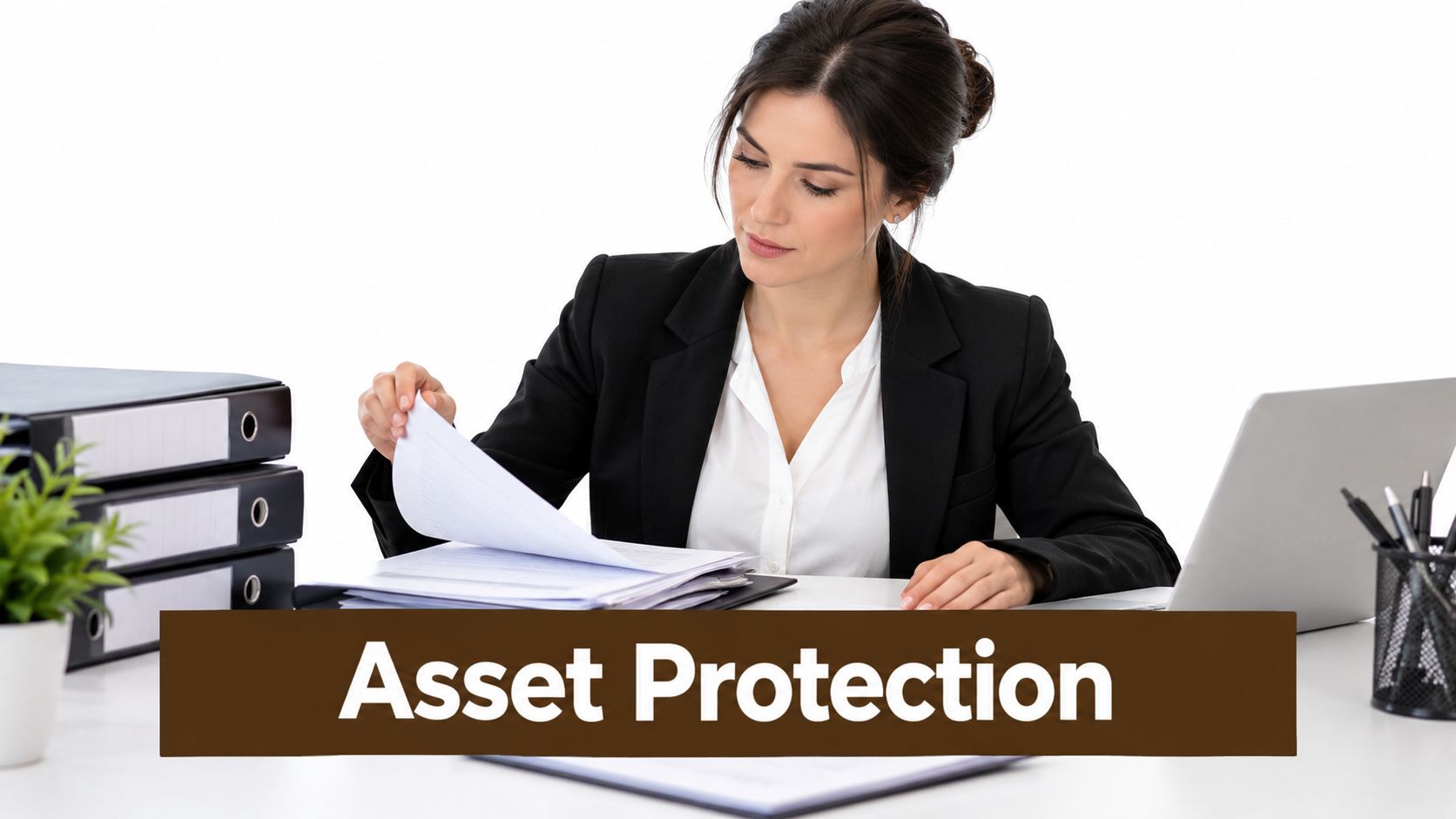A professional woman in a business suit reviewing financial documents at her desk for asset protection.